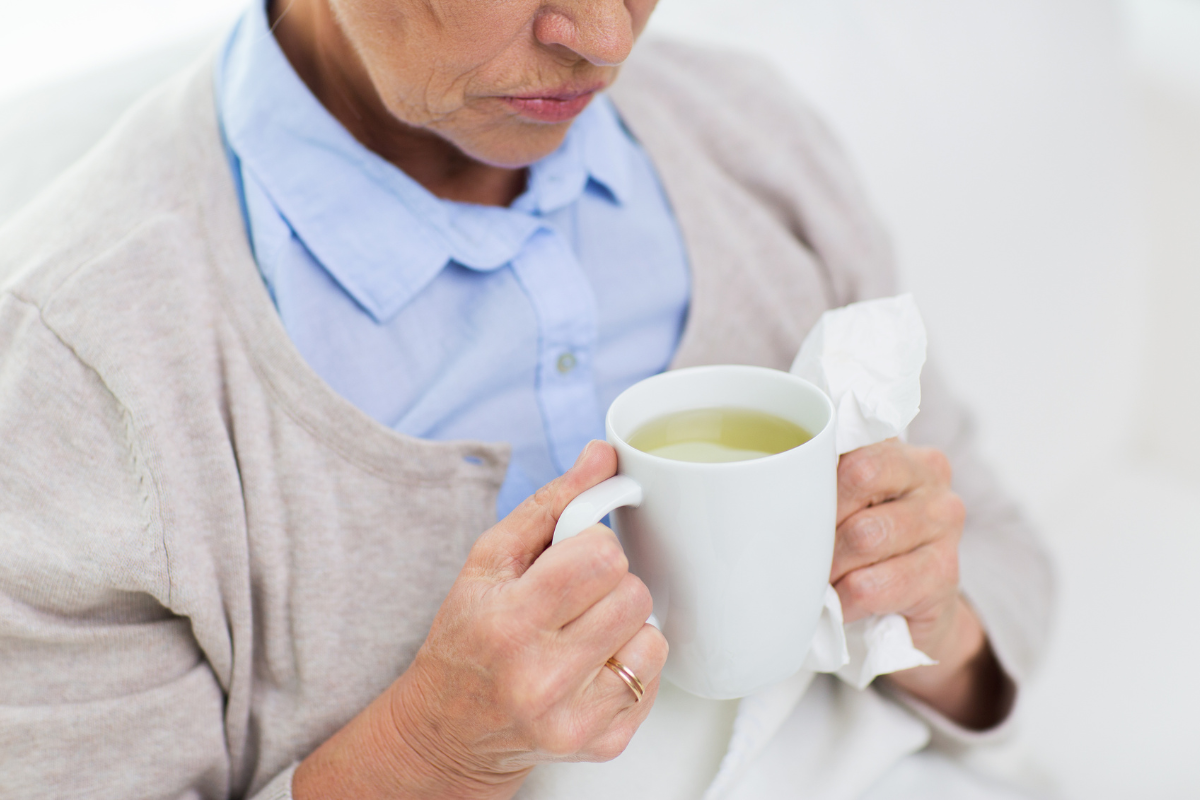 Person with stuffy nose drinking hot tea