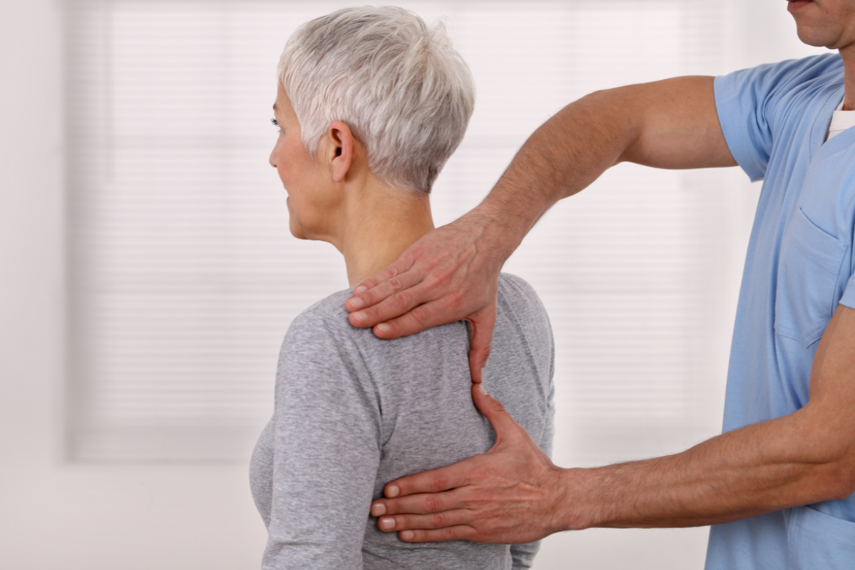 Mature woman receiving chiropractic adjustment on her back