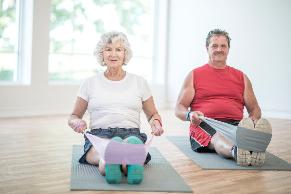 Older woman and man performing seated row with a resistance band