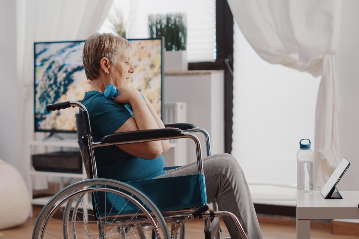 Woman in wheelchair doing bicep curls with dummbells