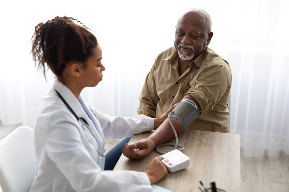 Healthcare provider taking older gentleman's blood pressure