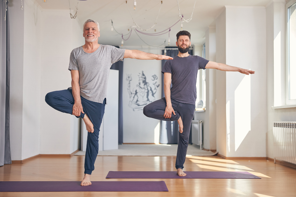 Two men performing modified tree pose yoga posture for balance