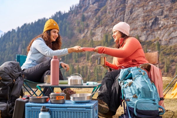 Two women sharing a meal while hiking up a mountain