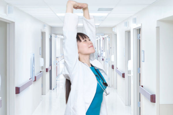 Healthcare professional stretching between seeing patients