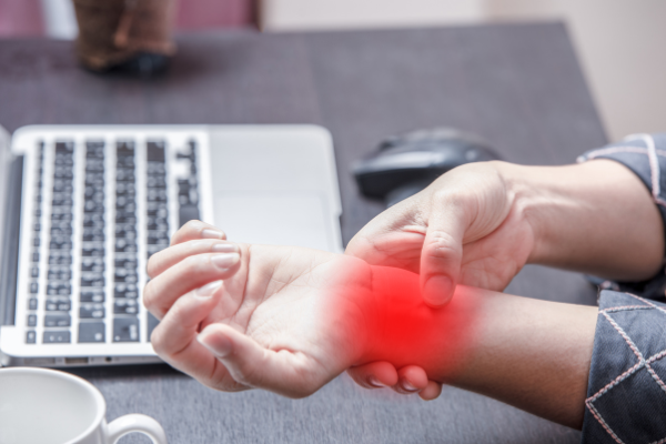 Representation of a painful wrist due to carpal tunnel from improper posture while working at a desk