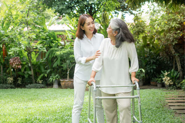 A caregiving daughter and her mother enjoying nature as they walk outside