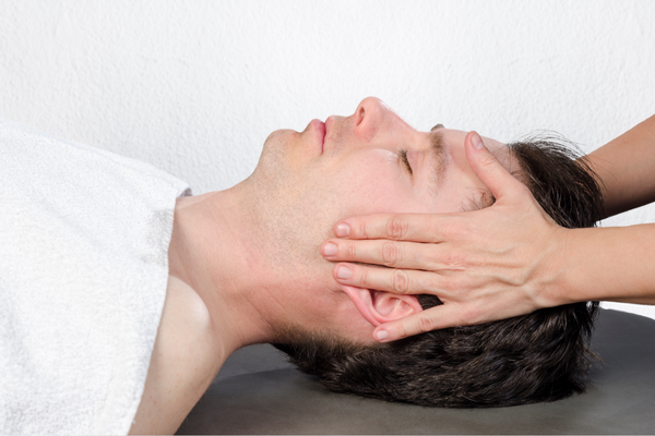 A chiropractor helping a man with TMJ symptoms