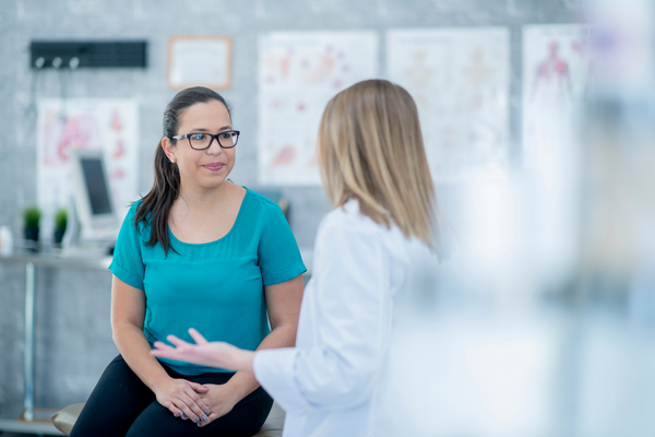 woman talking to healthcare provider, asking what is perimenopause and getting advice about HRT