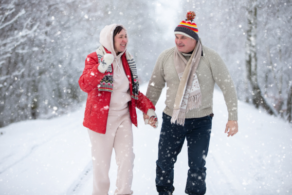 Couple preventing holiday exhaustion with enjoyable walk in the snow
