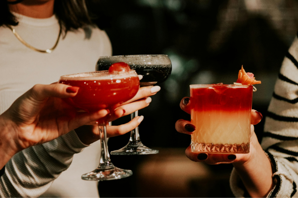 Women toasting the holidays with cocktails and mocktails