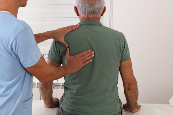 Older man being assessed by a chiropractor