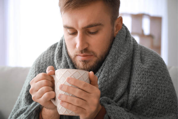 Sick man drinking warm tea