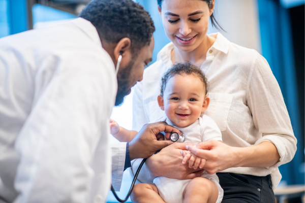 Pediatrician checking vitals and rotavirus symptoms for smiling baby