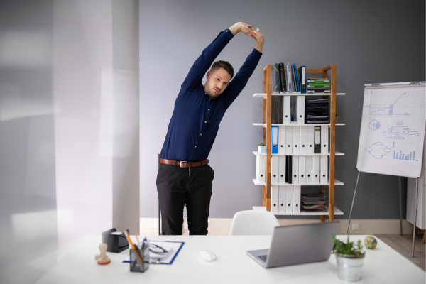 Man taking a break from his computer to do some side stretches